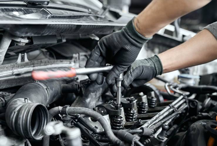 Car mechanic working on spark plugs