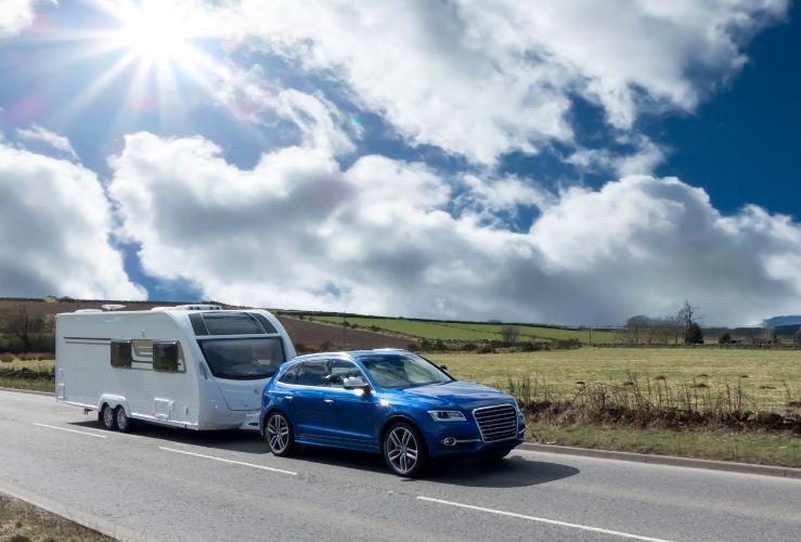 Car towing caravan on countryside road