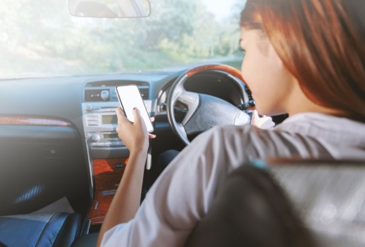 Woman texting on mobile phone whilst driving