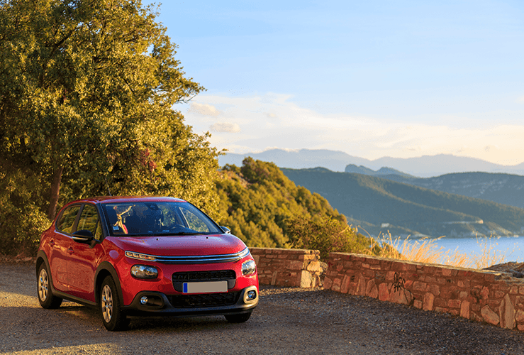 Red car parked on top of a raised road