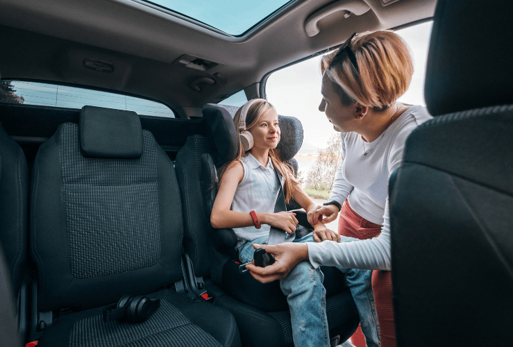 Child being strapped in to car seat