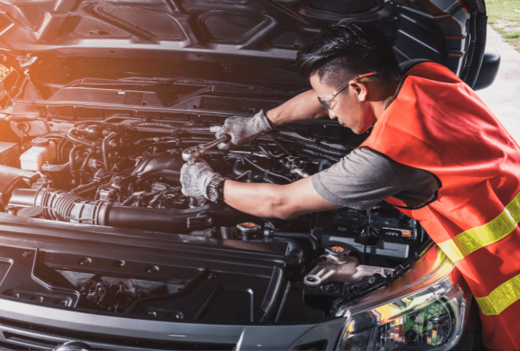 Mobile mechanic working on car engine