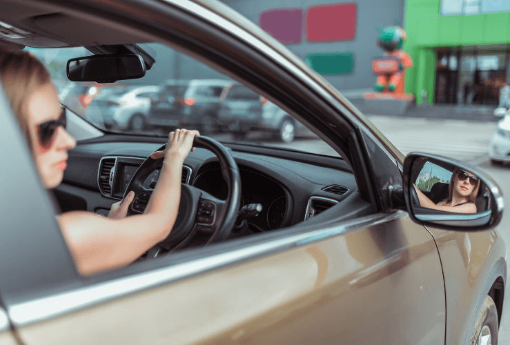 Young girl reversing car into parking bay